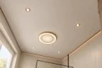 Тканевый натяжной потолок с видимой фактурой полотна, круглым светильником и встроенными спотами